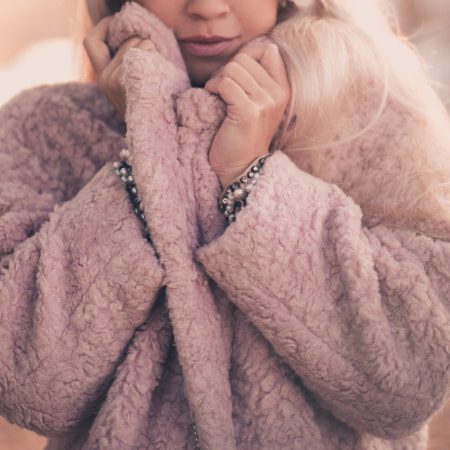 Blonde Ice Hockey Mom with plush soft pink coat