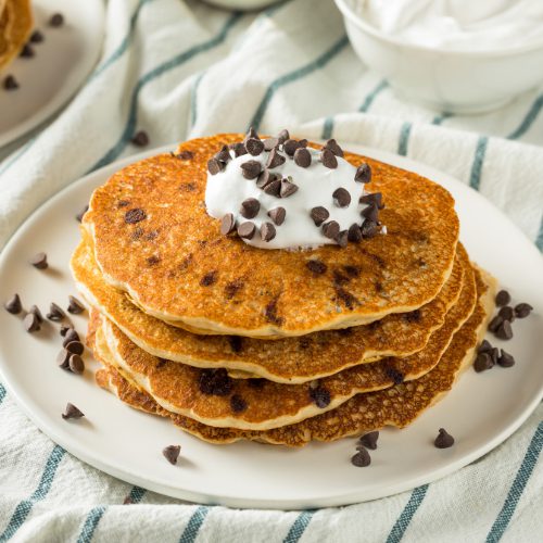 four chocolate chip pancakes with morsels and whipped cream