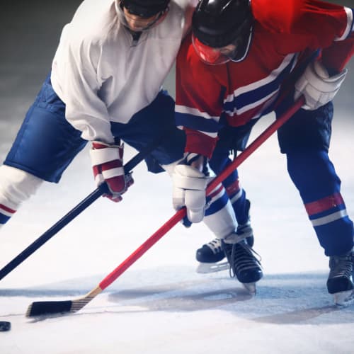 Two Ice Hockey players rushing for the puck