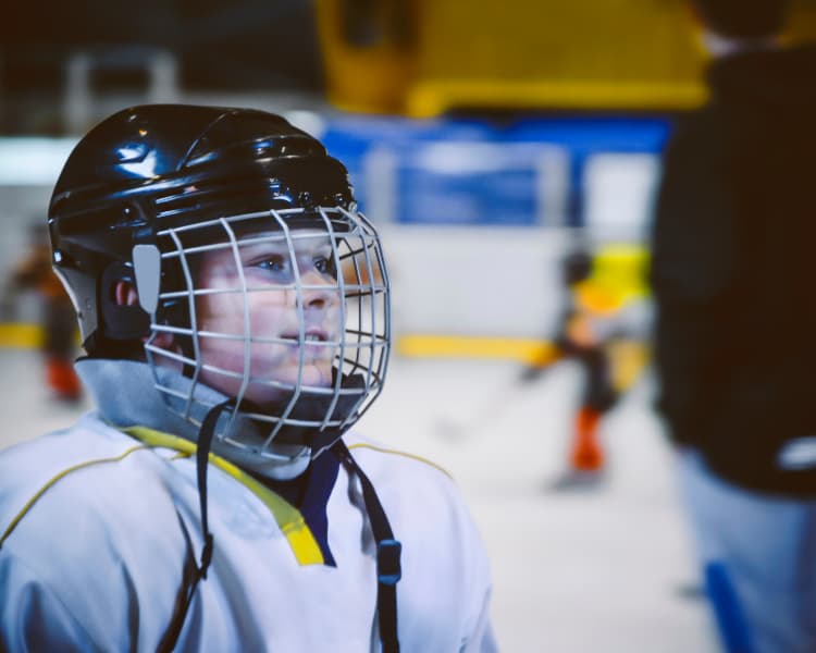 Picture of young boy with neck guard and helmet smiling