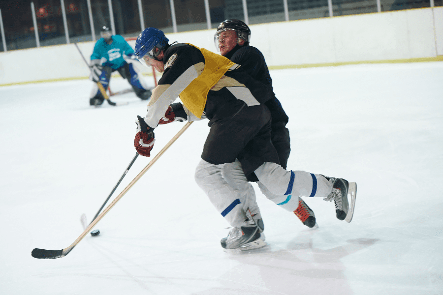 Two adult hokcey player one pefroming a Hooking penalty during Ice Hockey