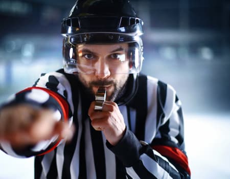 Ice hockey referee blowing his whistle