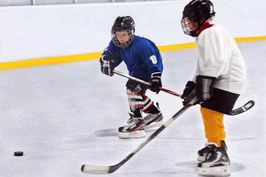 Two young children practicing ice hockey