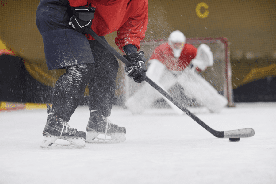 Ice hockey player shooting towards a goalie