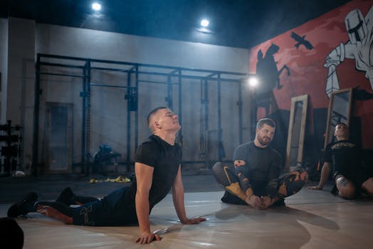 Man in Black Crew Neck T-shirt and Black Pants Sitting on Black Mat