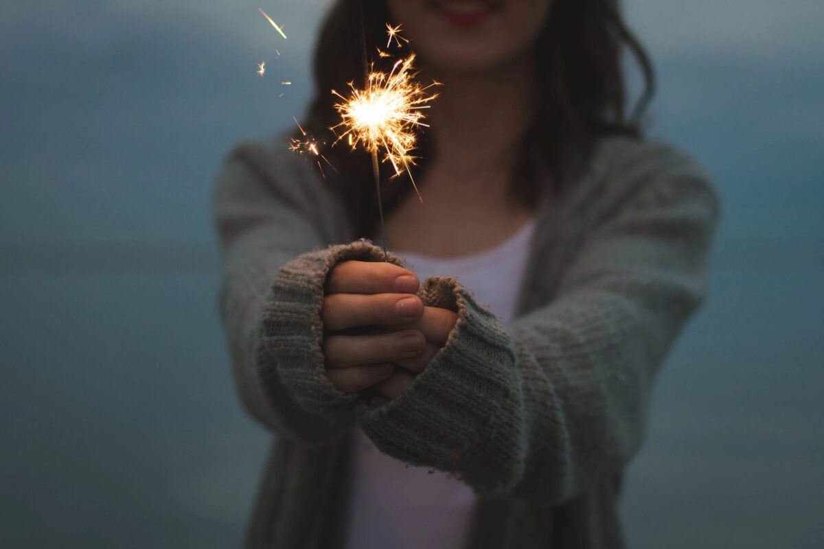 woman with sweater holding firecracker